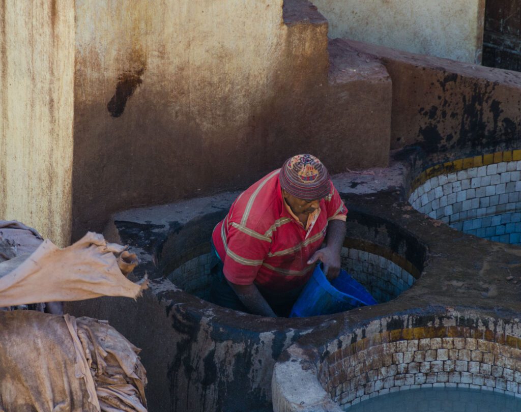 image of man working at tannery in Fez Morocco, editorial travel photography