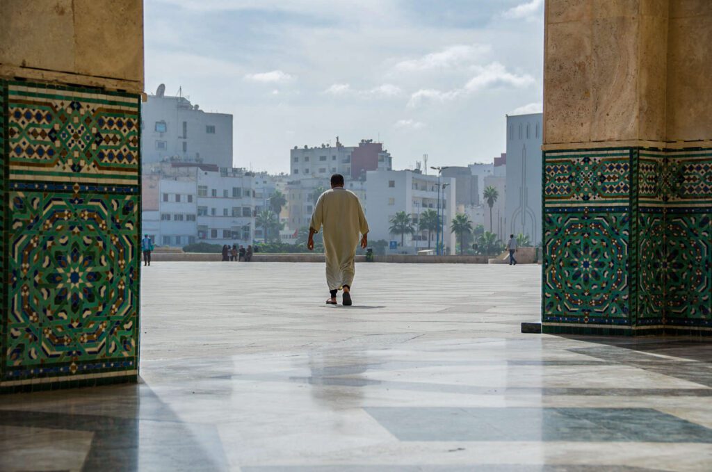 man walking Hassan II Mosque Morocco