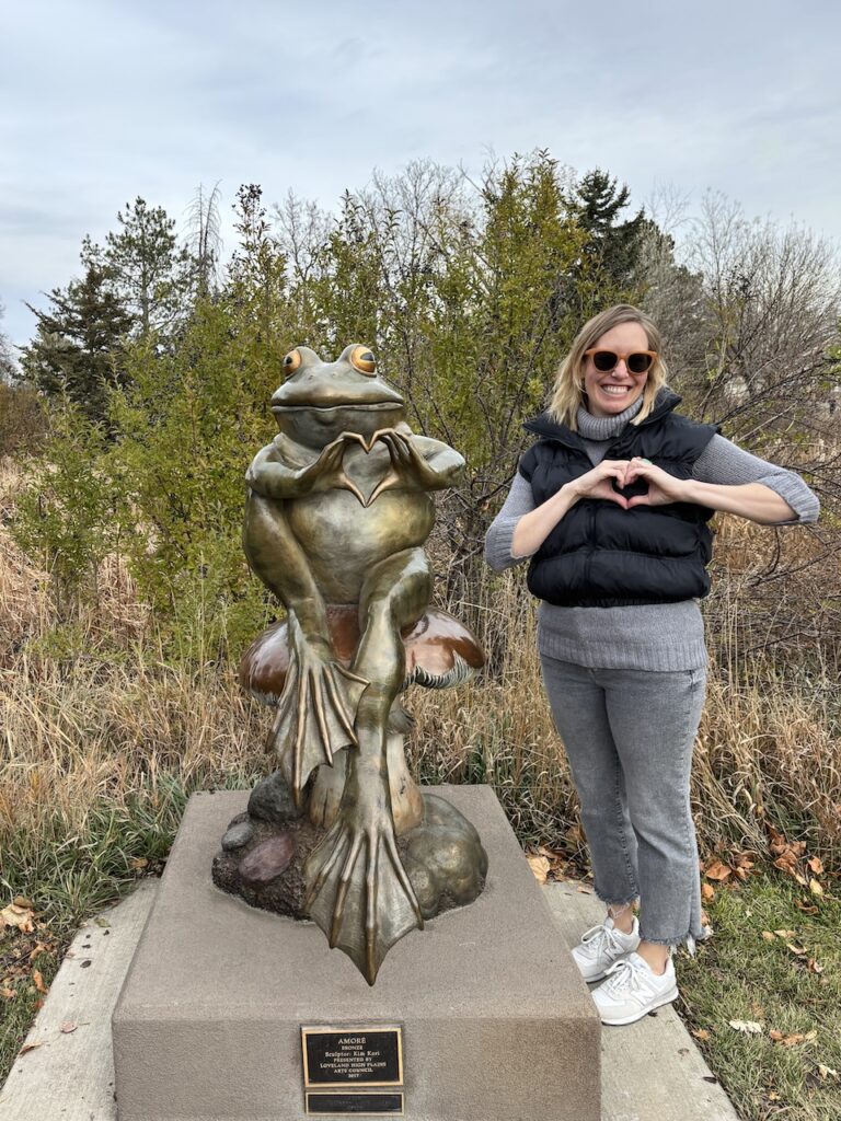 posing with the frog sculpture in Benson Sculpture Garden