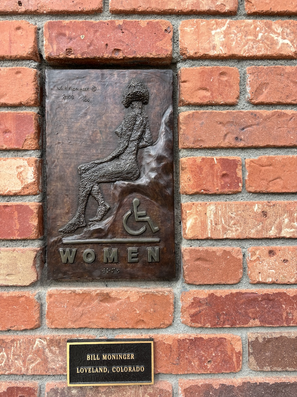 women's restroom sign made of bronze